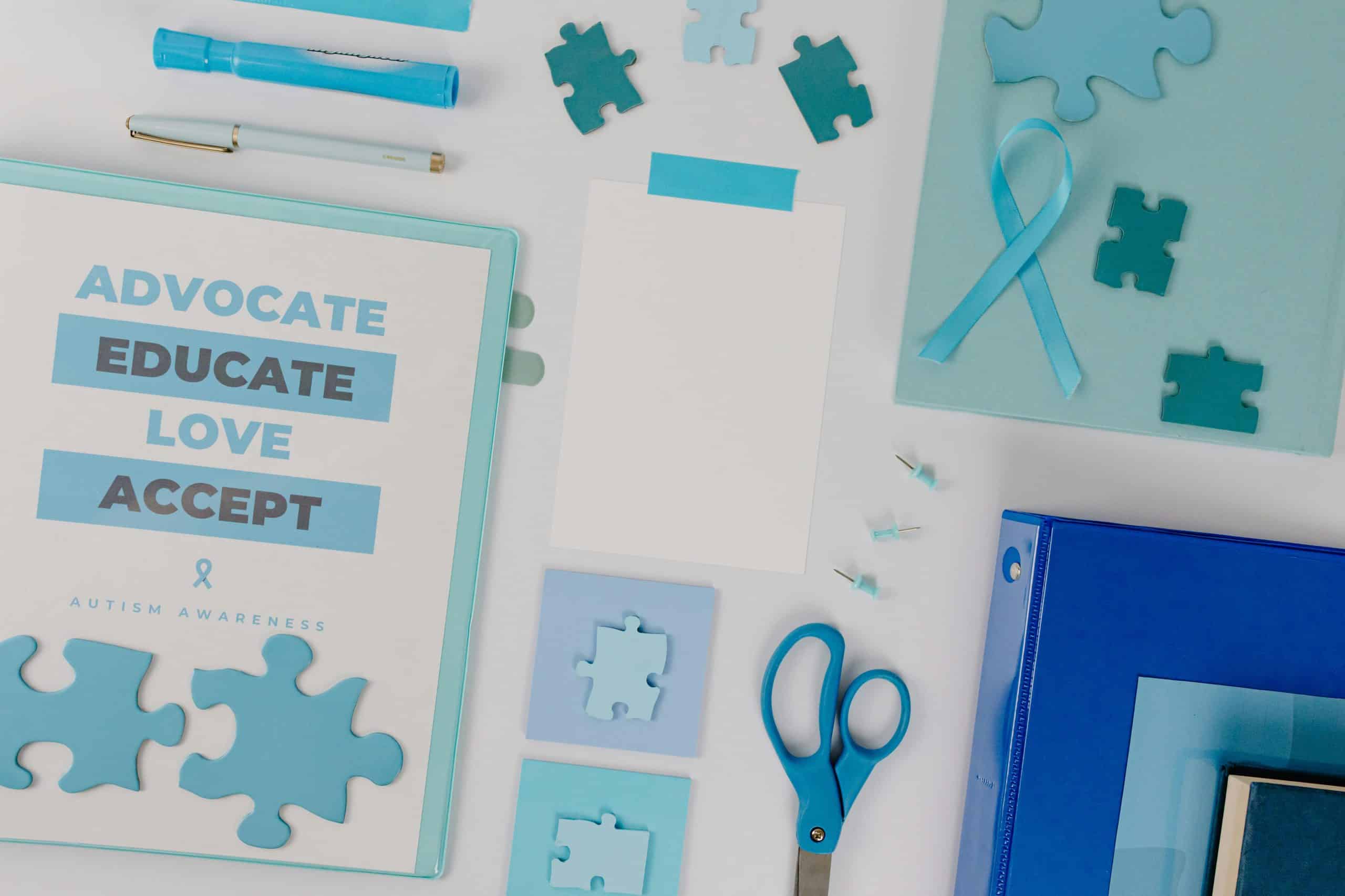 Autism awareness materials, including a blue ribbon and puzzle pieces, symbolizing NDIS support for individuals with autism.