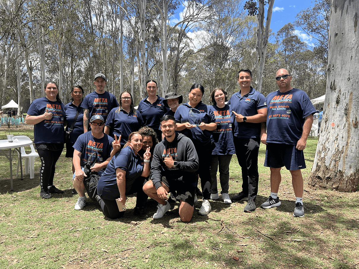 Meta Healthcare team celebrating together outdoors.