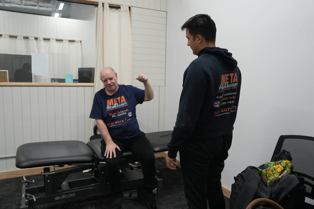 Interaction between a client and a support worker at META Healthcare, highlighting disability support services.