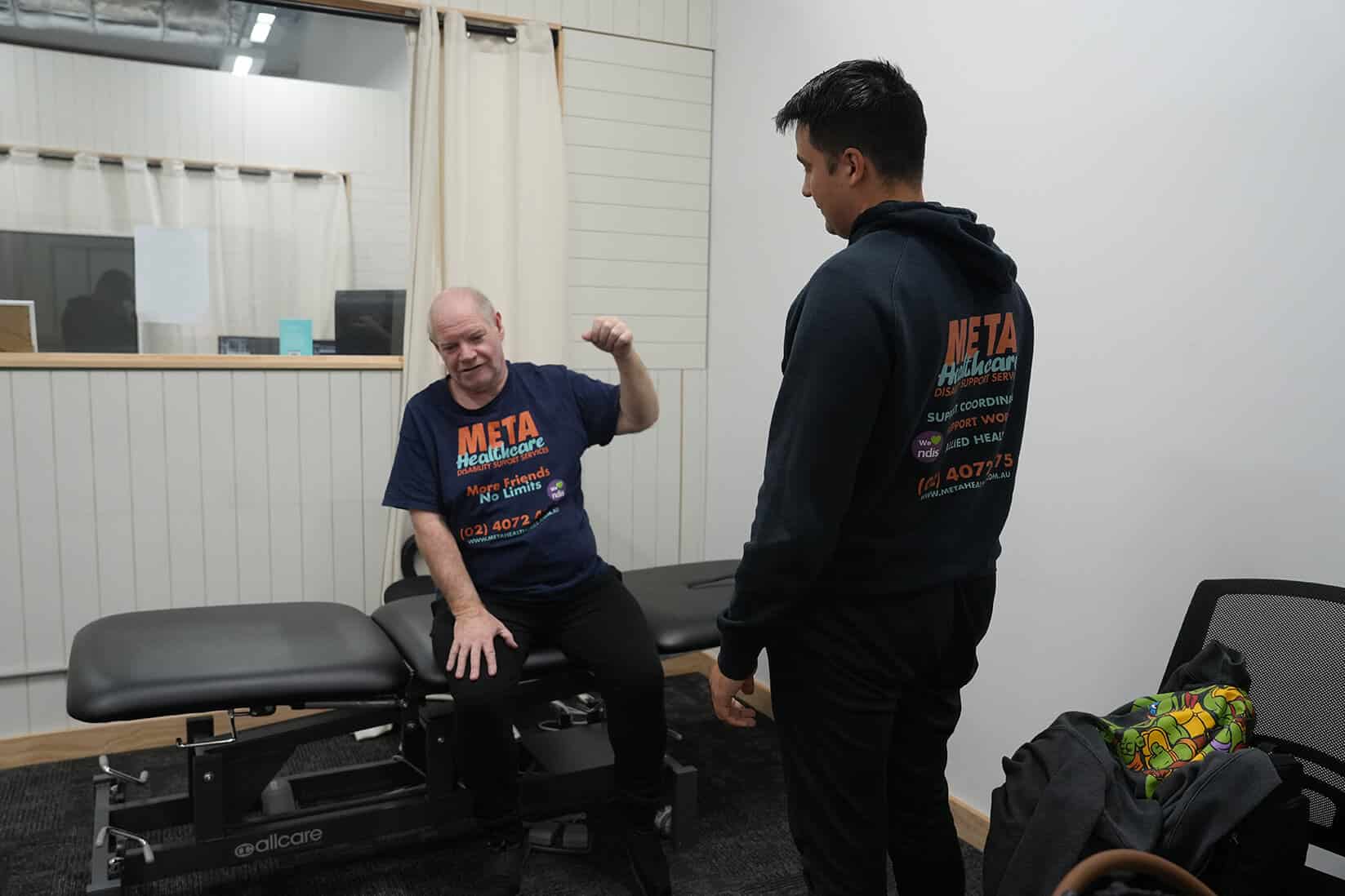 Interaction between a client and a support worker at META Healthcare, highlighting disability support services.