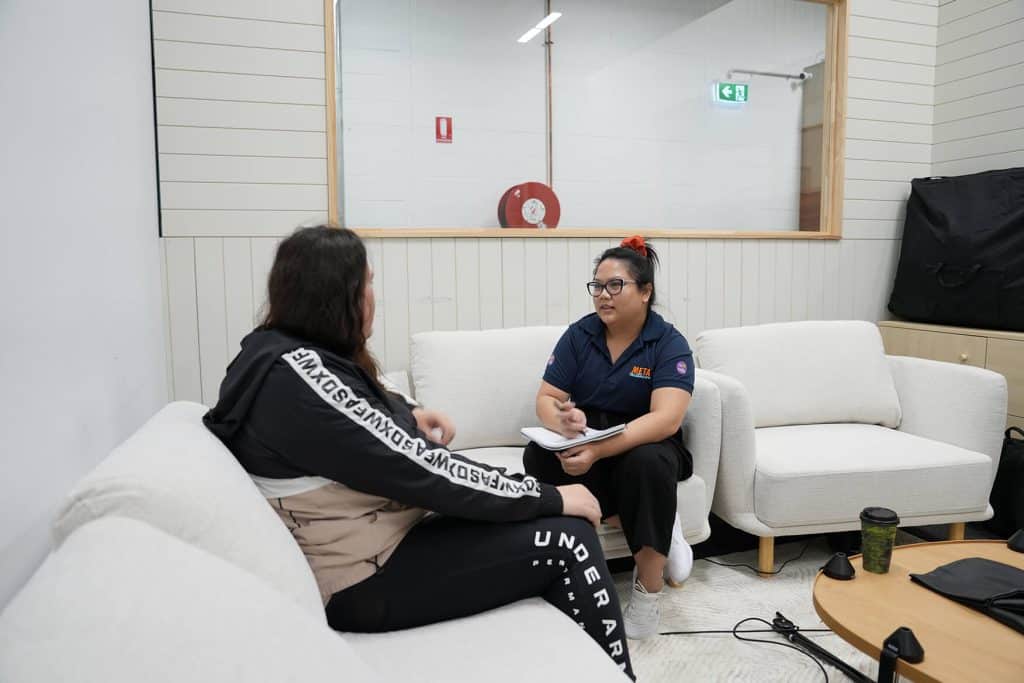 Two people engaged in a discussion in a modern office setting.