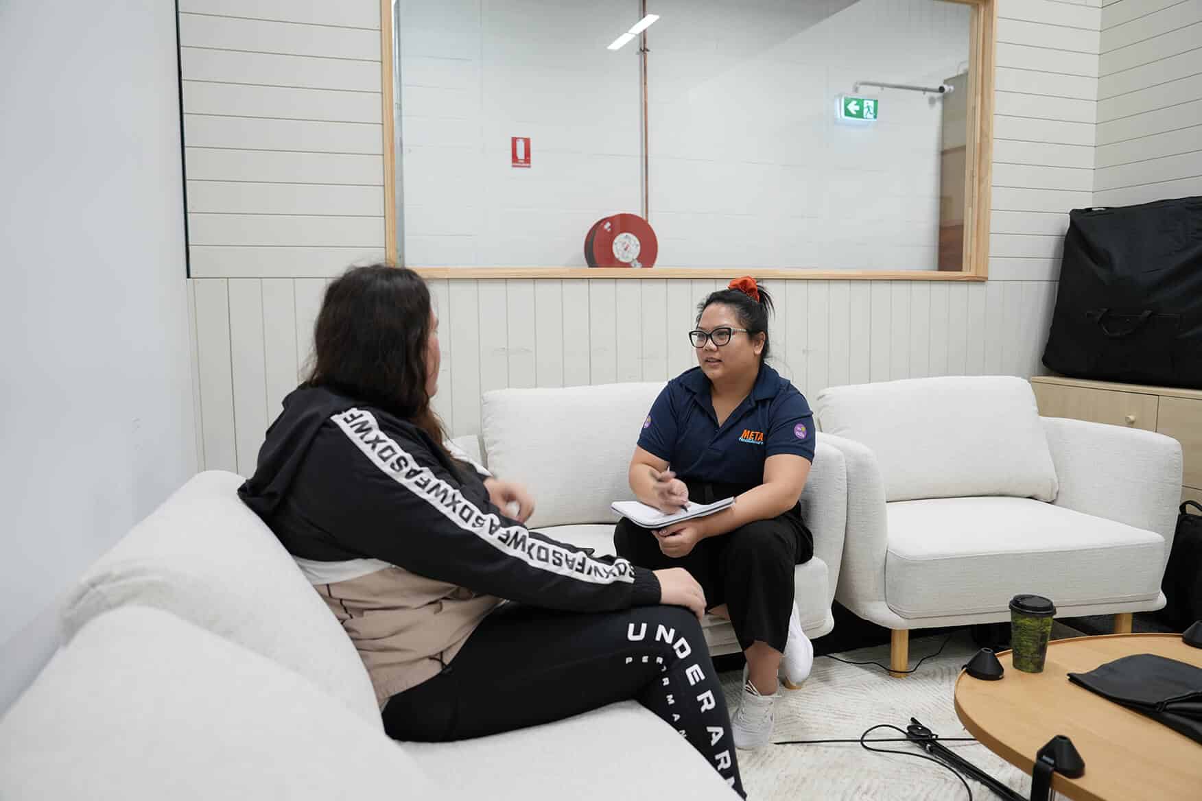 Two people engaged in a discussion in a modern office setting.