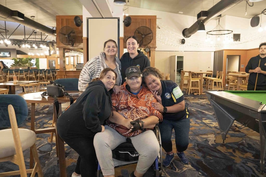 A joyful group of friends posing together in a bar setting.