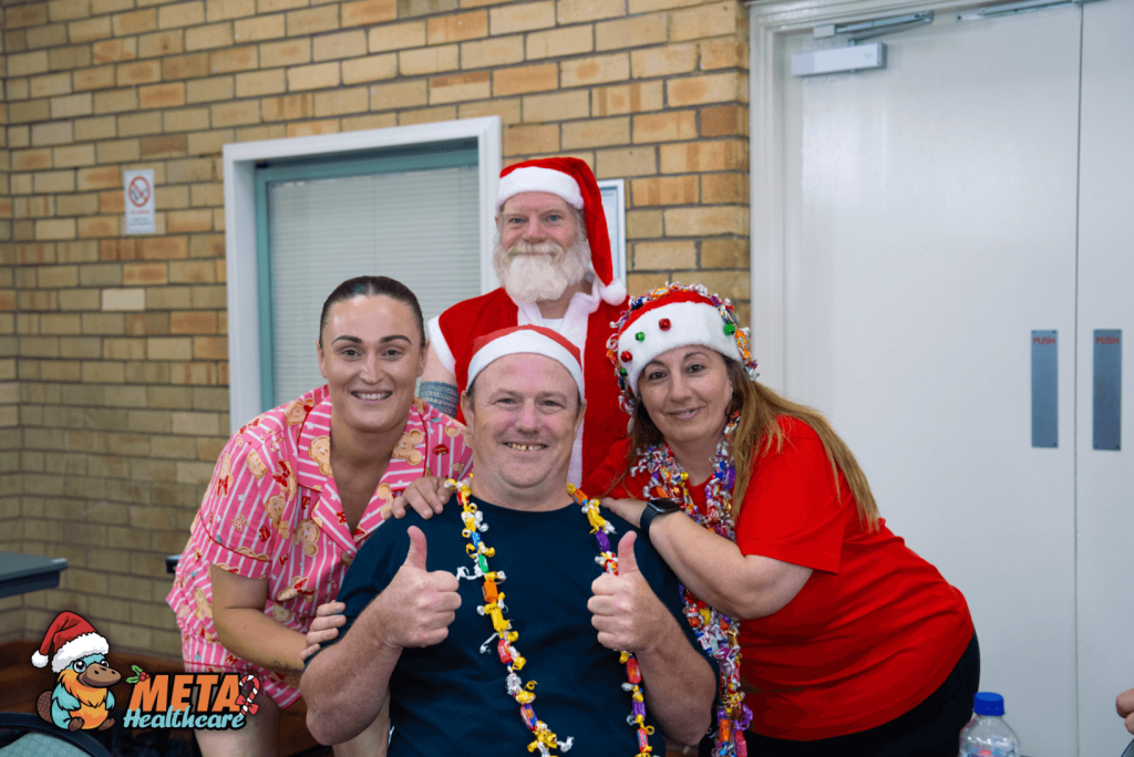 A joyful holiday celebration at Meta Healthcare with staff members dressed in festive attire.