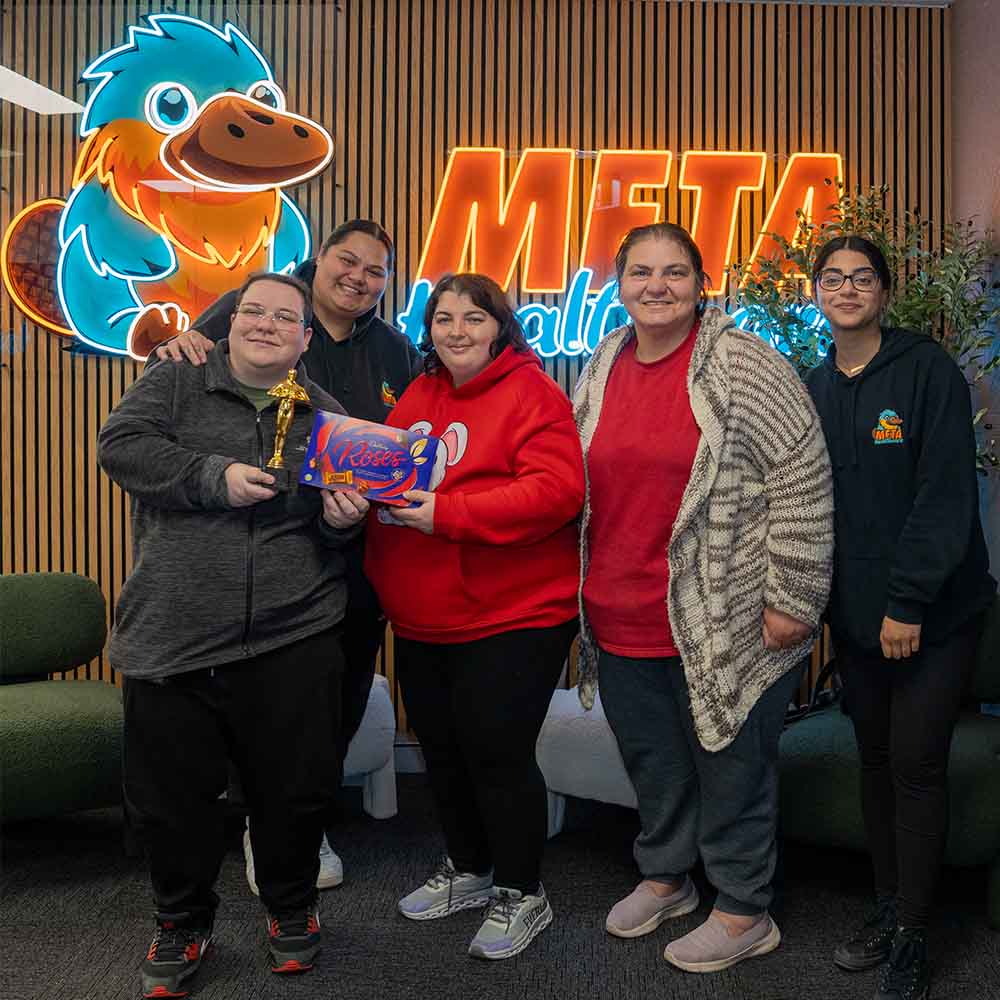 Team celebrating with awards and chocolates at Meta headquarters.