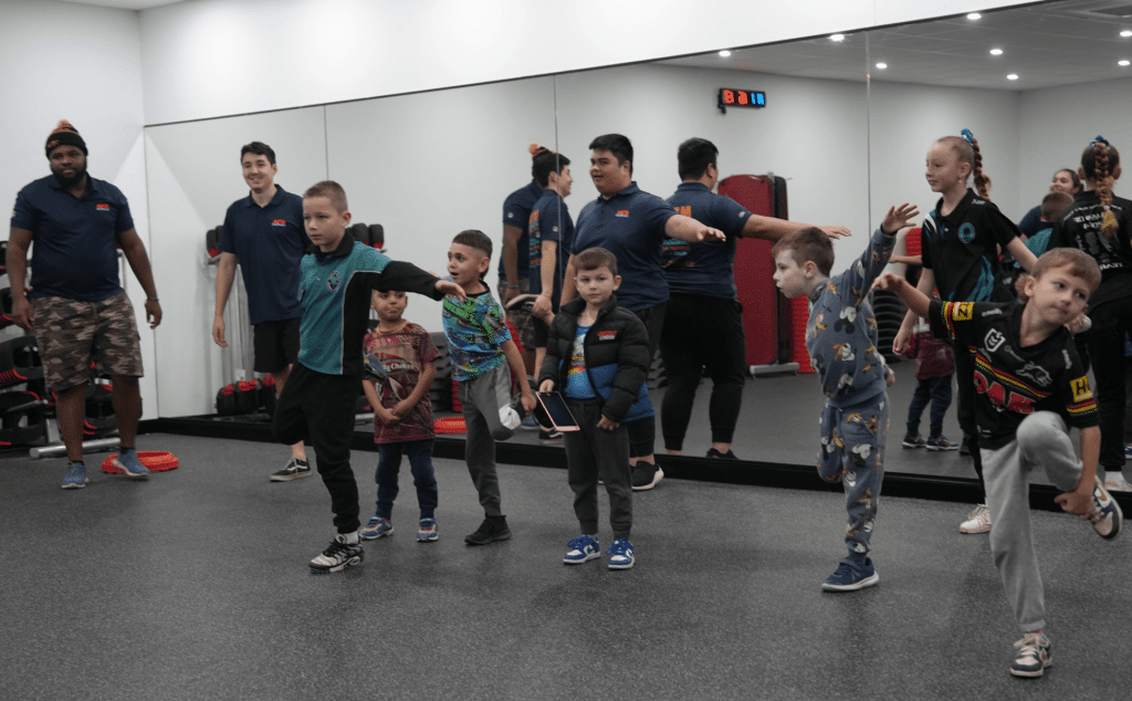 Children participating in a group movement activity with Meta Healthcare support staff
